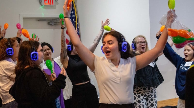 Kaylie Glenn and conference attendees raising maracas during a Memory Disco demonstration